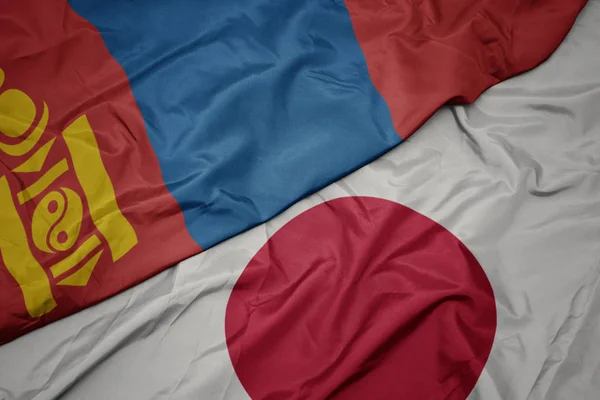 waving colorful flag of japan and national flag of mongolia.