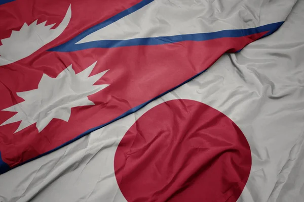 waving colorful flag of japan and national flag of nepal.