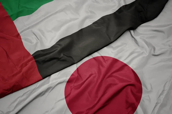Waving colorful flag of japan and national flag of united arab emirates. — Stock Photo, Image