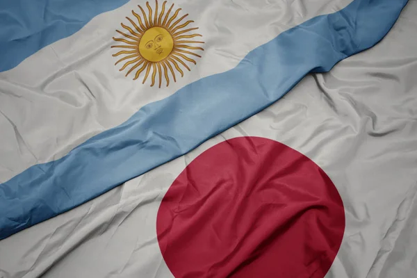 Размахивая красочным флагом Японии и национальным флагом Аргентины . — стоковое фото