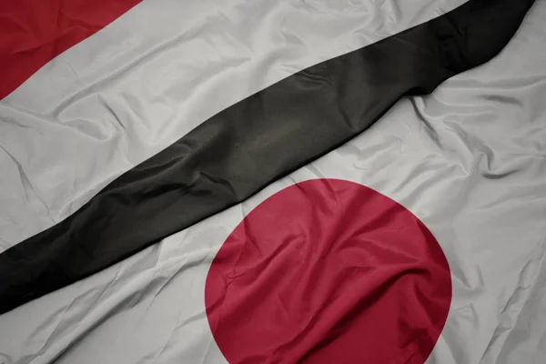 Acenando bandeira colorida do japão e bandeira nacional do Iêmen . — Fotografia de Stock