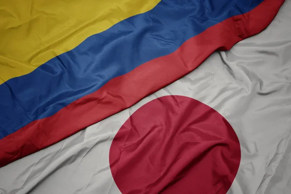 waving colorful flag of japan and national flag of colombia.