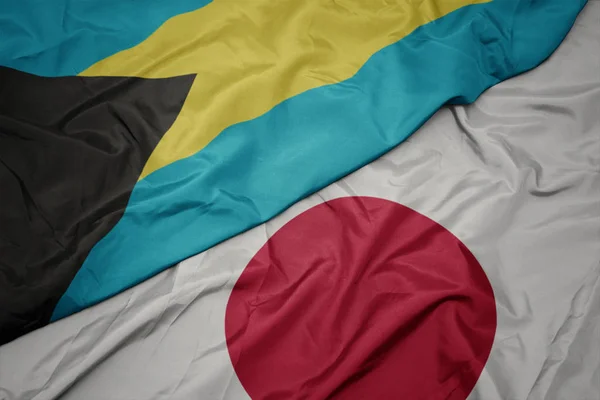 Mávající barevná vlajka Japonska a národní vlajka Baham. — Stock fotografie
