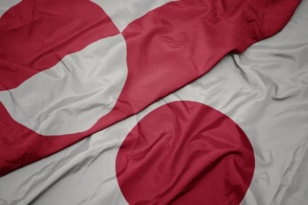 Acenando bandeira colorida do japão e bandeira nacional da Groenlândia . — Fotografia de Stock