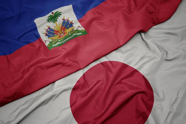 waving colorful flag of japan and national flag of haiti.