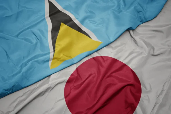 waving colorful flag of japan and national flag of saint lucia.