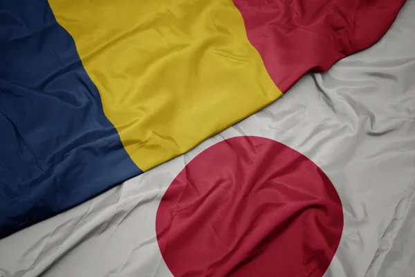 Zwaaiende kleurrijke vlag van Japan en de nationale vlag van Tsjaad. — Stockfoto