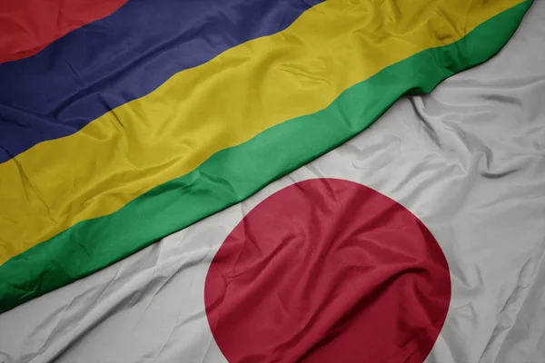 Mávající barevná vlajka Japonska a národní vlajka Mauricia. — Stock fotografie