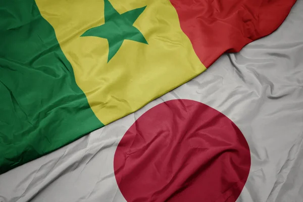 Acenando bandeira colorida do japão e bandeira nacional do Senegal . — Fotografia de Stock
