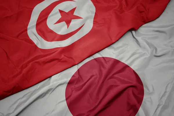 Waving colorful flag of japan and national flag of tunisia. — Stock Photo, Image