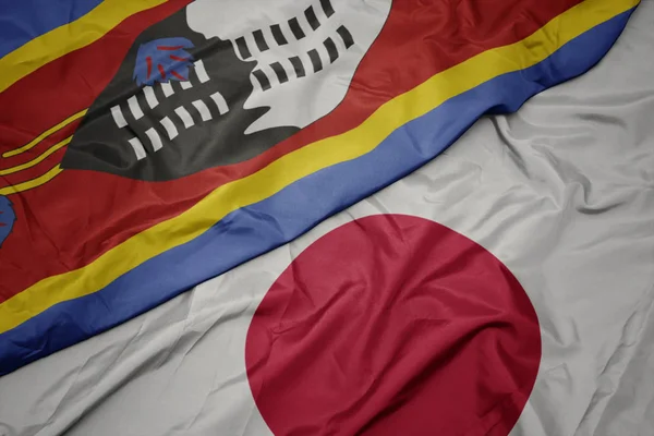waving colorful flag of japan and national flag of swaziland.