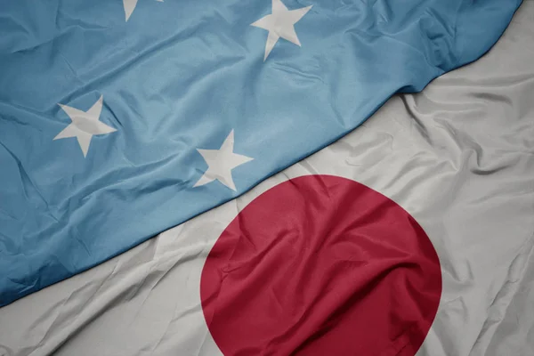 waving colorful flag of japan and national flag of Federated States of Micronesia.