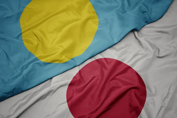 waving colorful flag of japan and national flag of Palau.