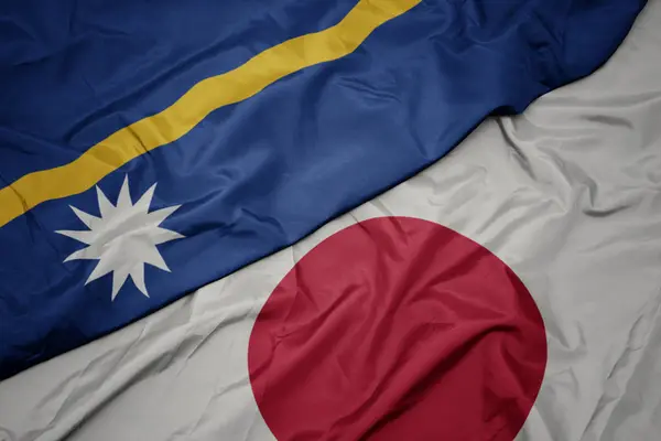waving colorful flag of japan and national flag of Nauru.