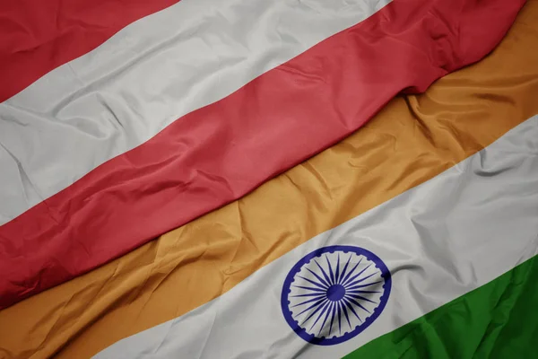 Agitant drapeau coloré de l'Inde et drapeau national de l'Autriche . — Photo