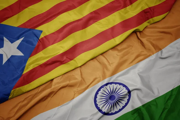 waving colorful flag of india and national flag of catalonia.