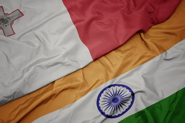 waving colorful flag of india and national flag of malta.