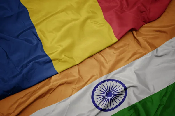 Agitant drapeau coloré de l'Inde et drapeau national de la Roumanie . — Photo