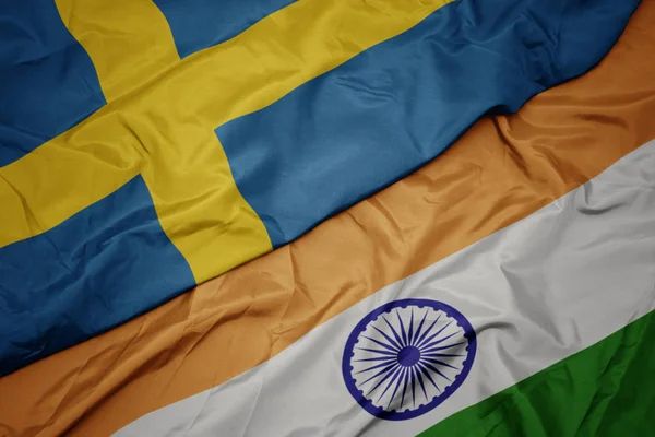 Agitant drapeau coloré de l'Inde et drapeau national de la Suède . — Photo