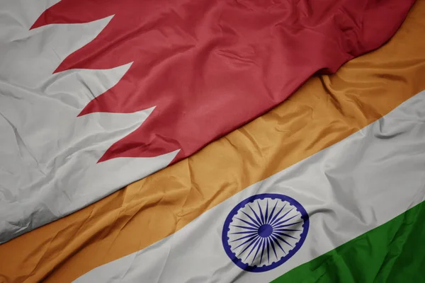 waving colorful flag of india and national flag of bahrain.