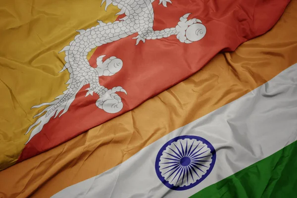 waving colorful flag of india and national flag of bhutan.