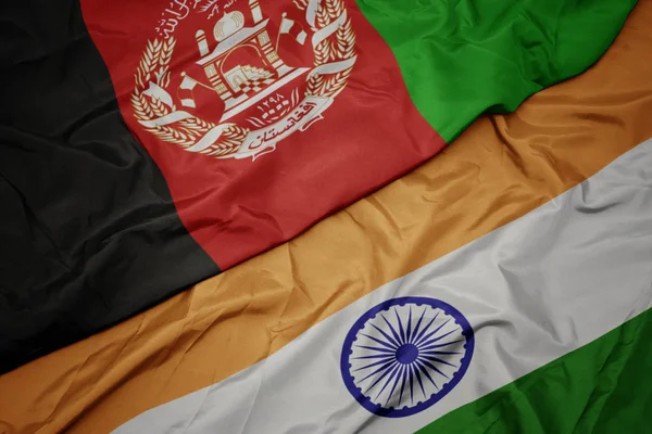 waving colorful flag of india and national flag of afghanistan.