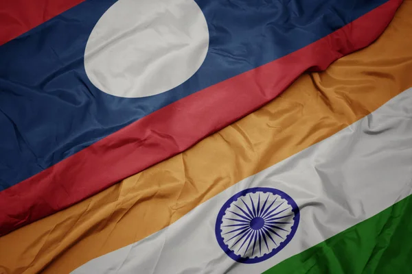 waving colorful flag of india and national flag of laos.