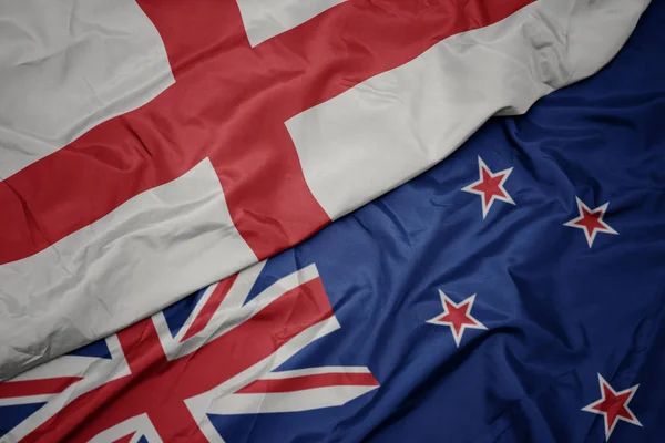 Waving colorful flag of new zealand and national flag of england. — Stock Photo, Image