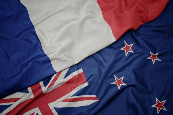 Waving colorful flag of new zealand and national flag of france. — Stock Photo, Image