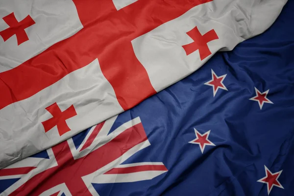 Waving colorful flag of new zealand and national flag of georgia. — Stock Photo, Image