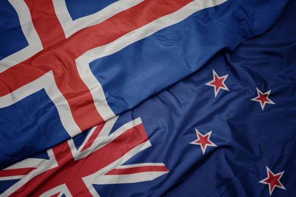 Acenando bandeira colorida da Nova Zelândia e bandeira nacional da Islândia . — Fotografia de Stock
