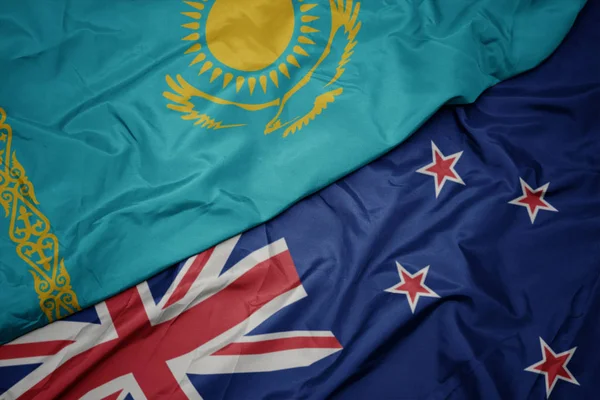 Acenando bandeira colorida da Nova Zelândia e bandeira nacional do Cazaquistão . — Fotografia de Stock