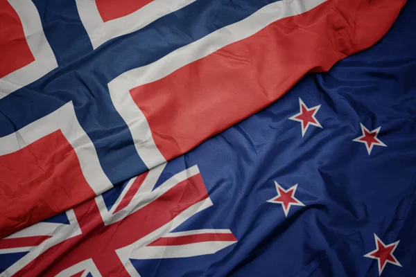 Agitant drapeau coloré de la Nouvelle-Zélande et drapeau national de norway . — Photo