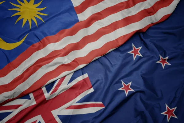 Размахивая красочным флагом Новой Зеландии и национальным флагом Малайзии . — стоковое фото