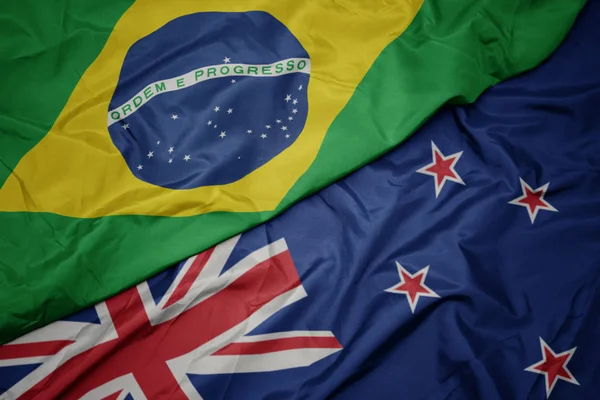 Falujące kolorowe flagi Nowej Zelandii i flagi narodowej Brazylii. — Zdjęcie stockowe