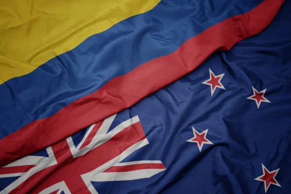 Schwenken bunte Flagge von Neuseeland und kolumbianische Nationalflagge. — Stockfoto
