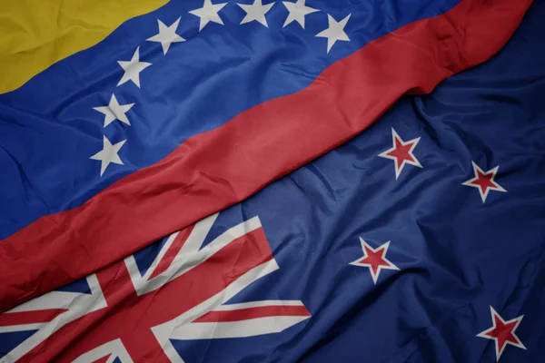 Хвилястий барвистий прапор Нової Зеландії та національний прапор Венесуели . — стокове фото