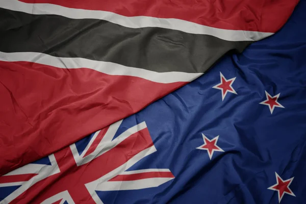 Agitant le drapeau coloré de la Nouvelle-Zélande et le drapeau national de Trinidad et tobago . — Photo