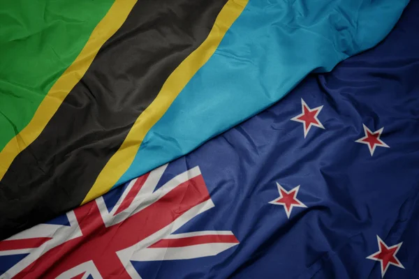Agitant drapeau coloré de la Nouvelle-Zélande et drapeau national de la tanzanie . — Photo