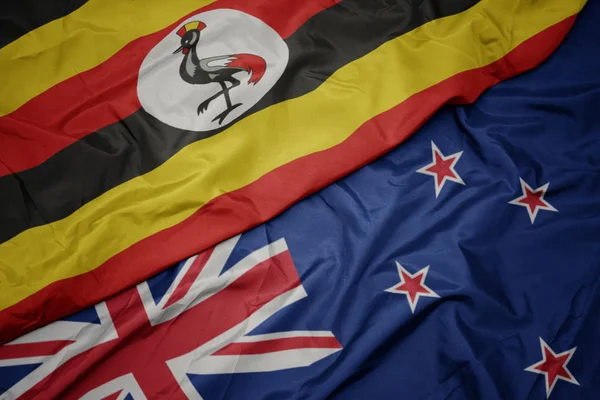 Waving colorful flag of new zealand and national flag of uganda. — Stock Photo, Image