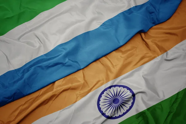 Agitant drapeau coloré de l'Inde et drapeau national de la Sierra Leone . — Photo