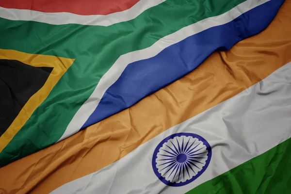 waving colorful flag of india and national flag of south africa.