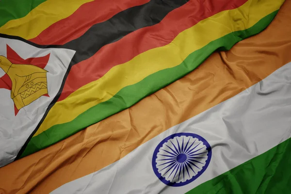 Acenando bandeira colorida da Índia e bandeira nacional de zimbabwe . — Fotografia de Stock