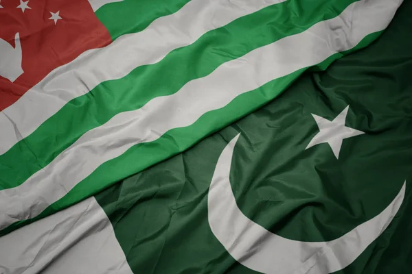 Zwaaiende kleurrijke vlag van Pakistan en de nationale vlag van Abchazië. — Stockfoto