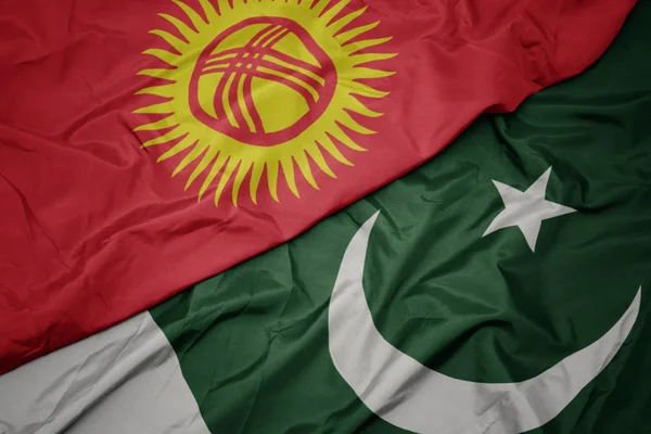 Acenando bandeira colorida do Paquistão e bandeira nacional do Quirguistão . — Fotografia de Stock