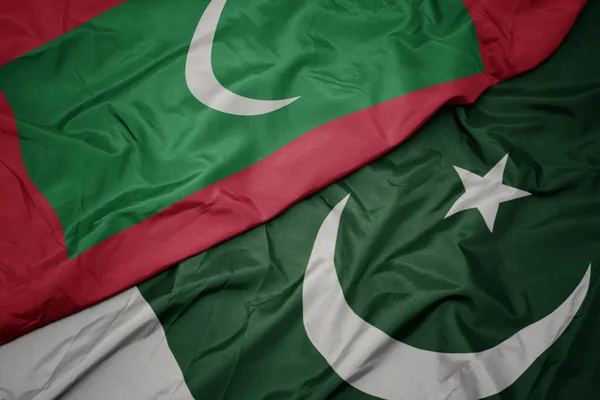 Sventolando bandiera colorata del pakistan e bandiera nazionale delle Maldive . — Foto Stock