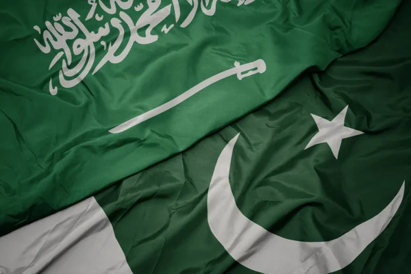 Zwaaiende kleurrijke vlag van Pakistan en de nationale vlag van Saoedi-Arabië. — Stockfoto