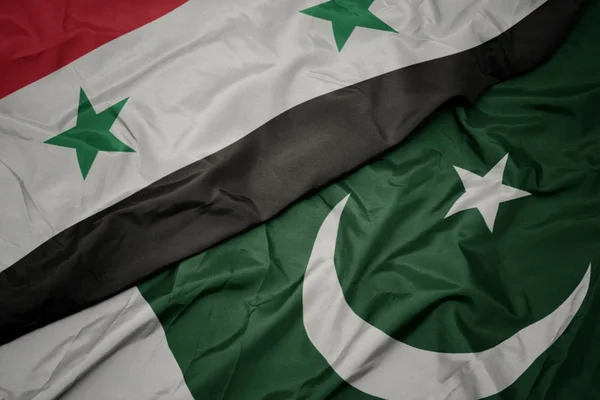 Waving colorful flag of pakistan and national flag of syria. — Stock Photo, Image