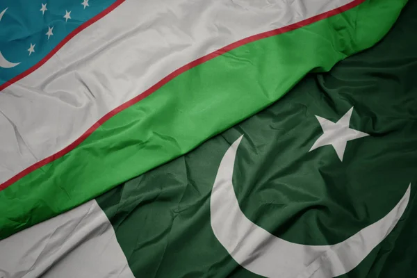 Waving colorful flag of pakistan and national flag of uzbekistan. — Stock Photo, Image