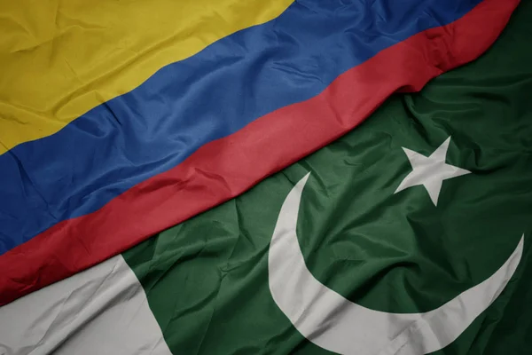 Zwaaiende kleurrijke vlag van Pakistan en de nationale vlag van Colombia. — Stockfoto